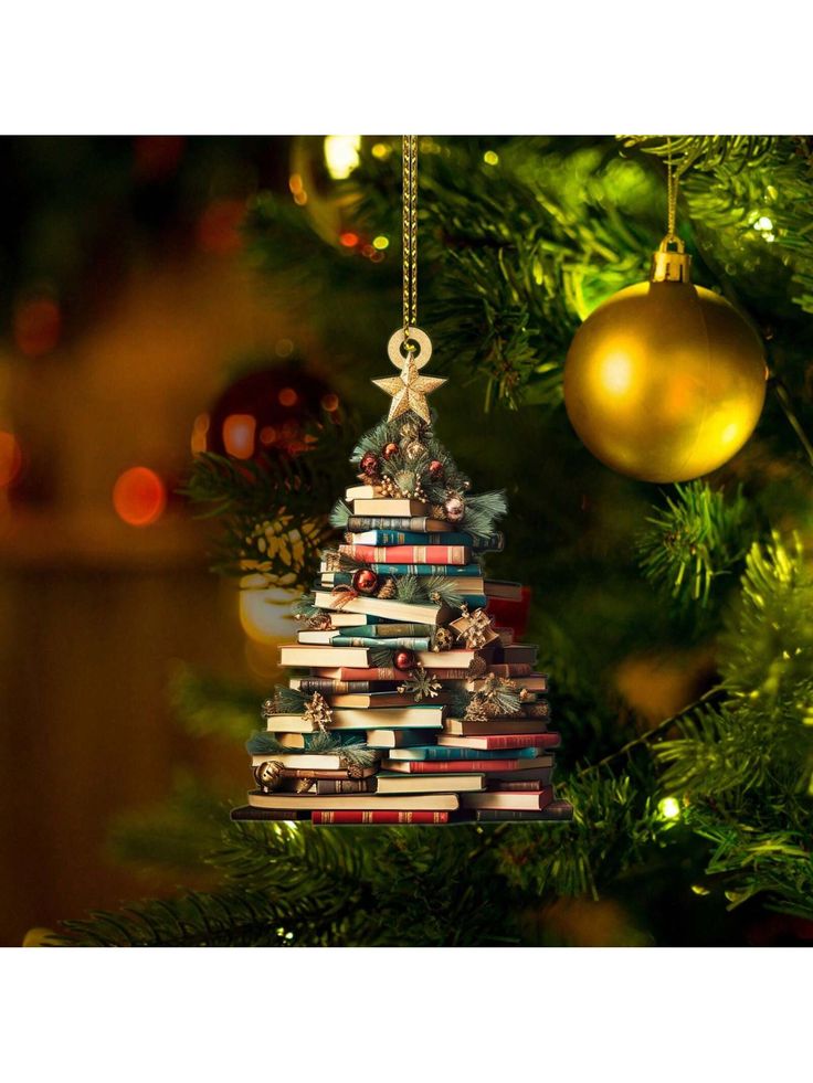 a christmas tree made out of books hanging from the side of a green christmas tree