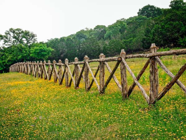 a wooden fence in the middle of a field