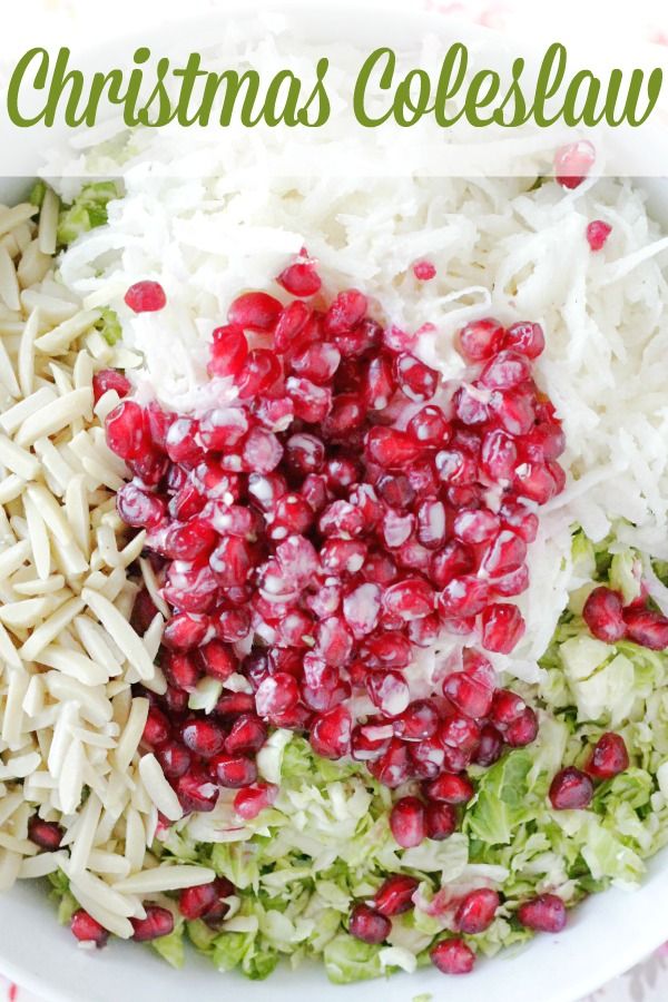 christmas coleslaw with shredded cheese and pomegranates in a white bowl