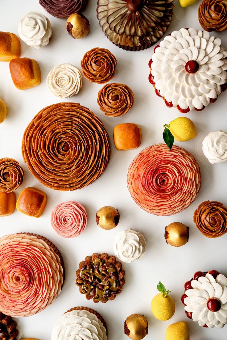 many different types of pastries are arranged on a white surface