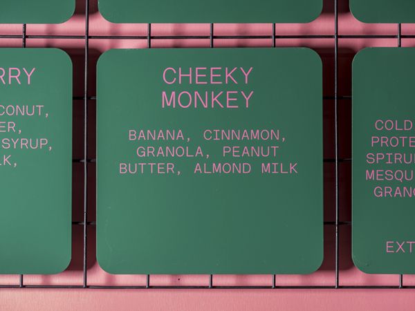 four signs on the side of a wall that say cherry, cheeky monkey, banana, cinnamon, peanut butter, almond milk, and honey