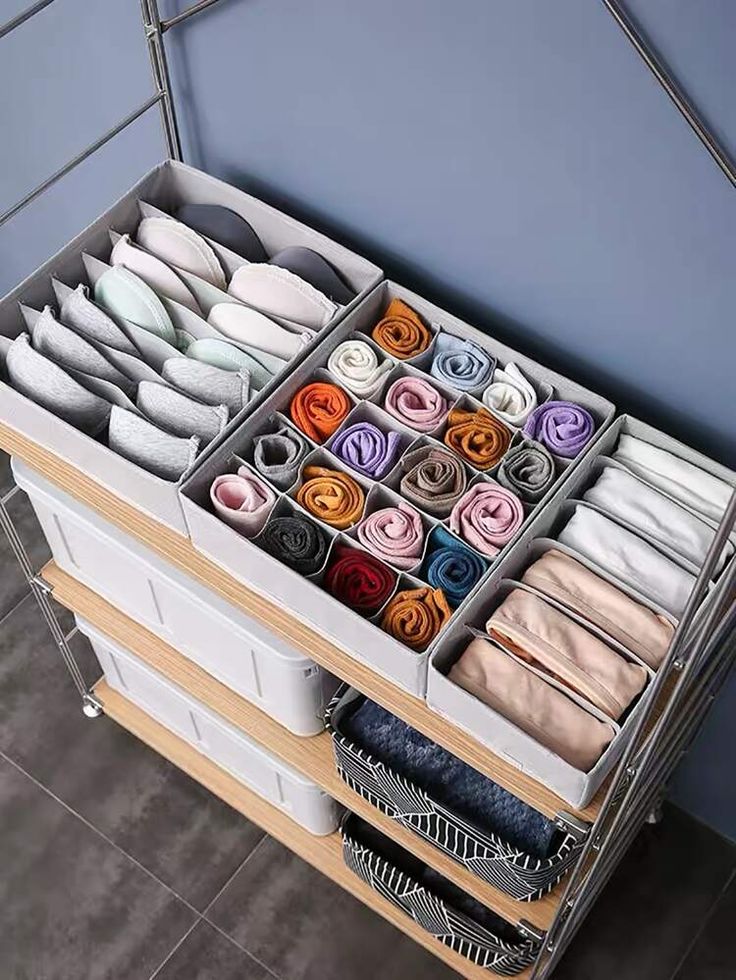 an organized drawer is shown with folded clothes and socks on it's trays