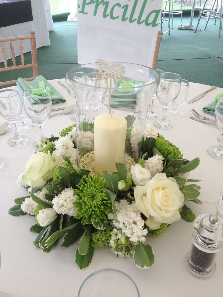 an image of a table setting with flowers and candles on the centerpiece, which reads aid green and cream themed wedding at article from flickr