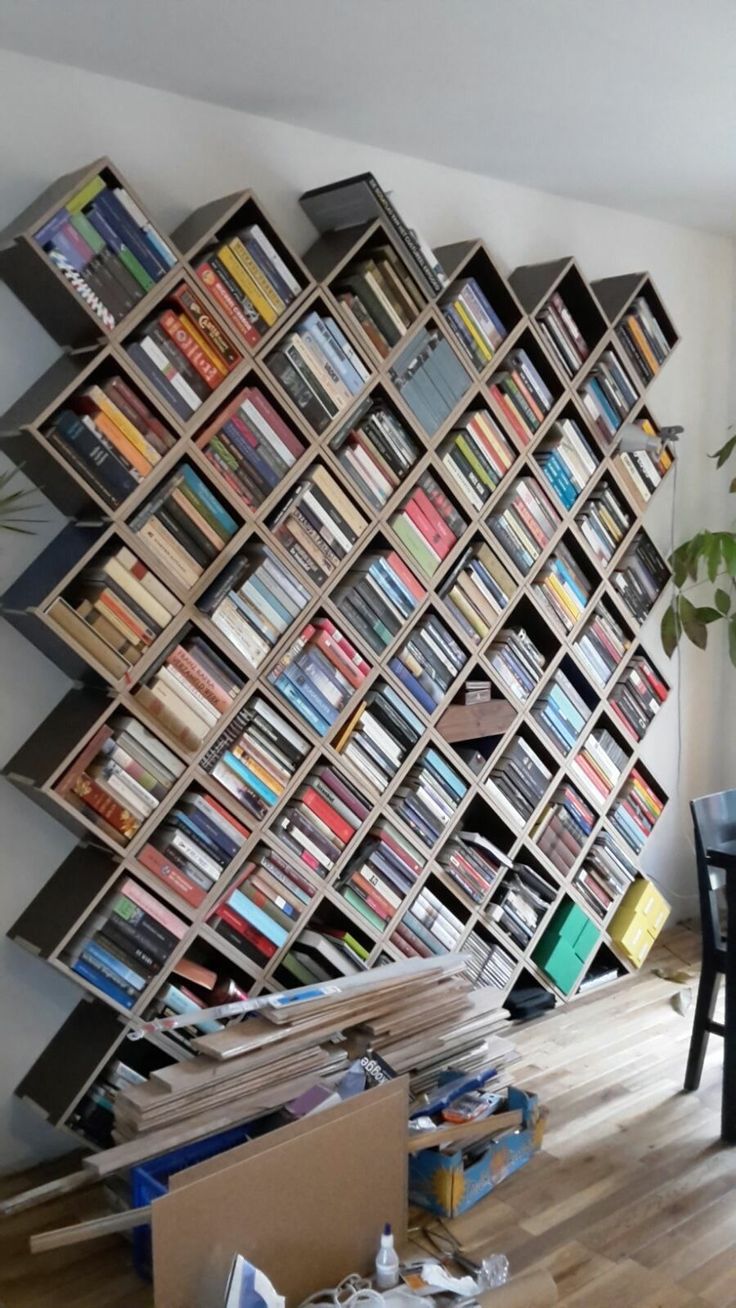 a large book shelf filled with lots of books on top of a hard wood floor