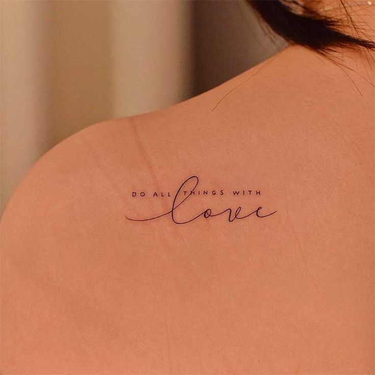 the back of a woman's shoulder with a tattoo saying do all things with love