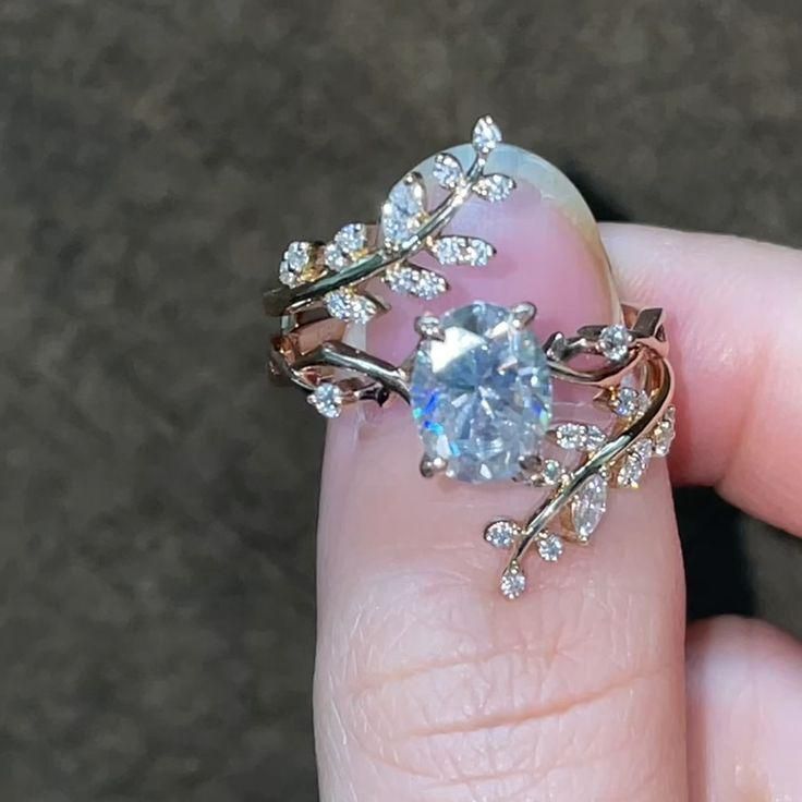 a woman's hand holding a ring with an aqua blue stone surrounded by white diamonds