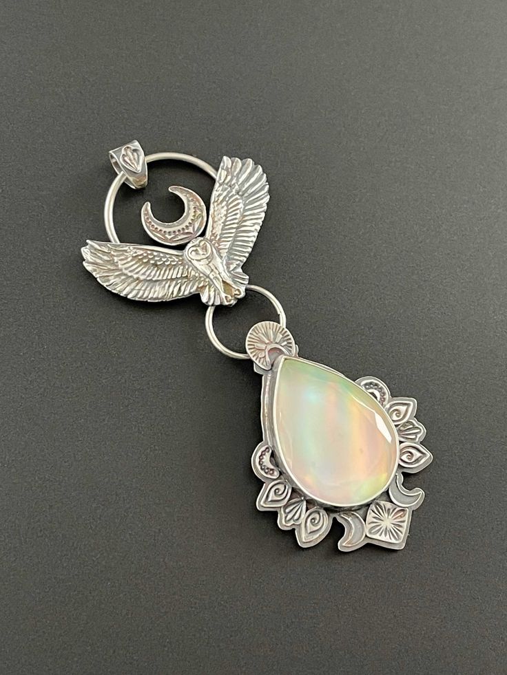 This is a solid silver owl soaring, and below it carries a gorgeous aurora opal. This is a synthetic type of opal, but they are very beautiful and have many flashing colors. This one has greens, blues, pinks, even purples among some other colors. The design is accented by hand stamped designs.  This pendant is solid sterling silver and is a handmade one of a kind piece. This is a beautiful piece, a statement, a talisman. It carries the energy of the owl.  This pendant does not come with a chain. Independent Thinking, Owl Accessories, Aurora Opal, Soldered Jewelry, Sterling Silver Owl, Cosmic Consciousness, 3d Jewelry, Types Of Opals, Supernatural Power