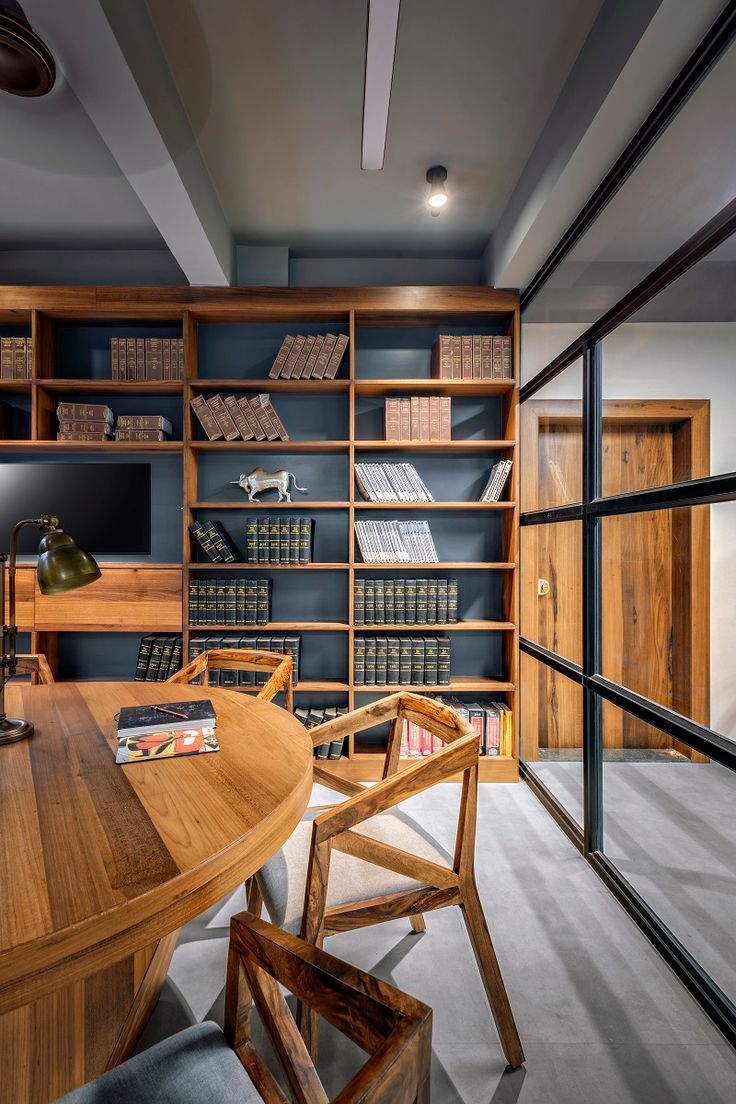 a wooden table sitting in front of a book shelf filled with books