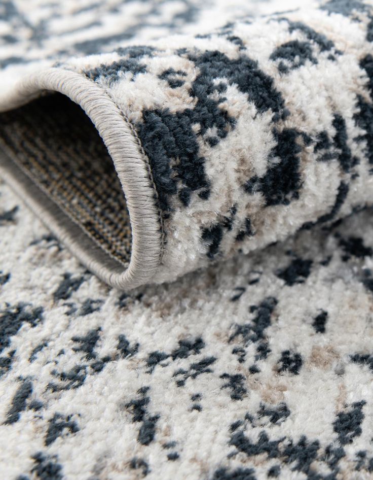 a close up view of a rug with black and white designs on it's surface