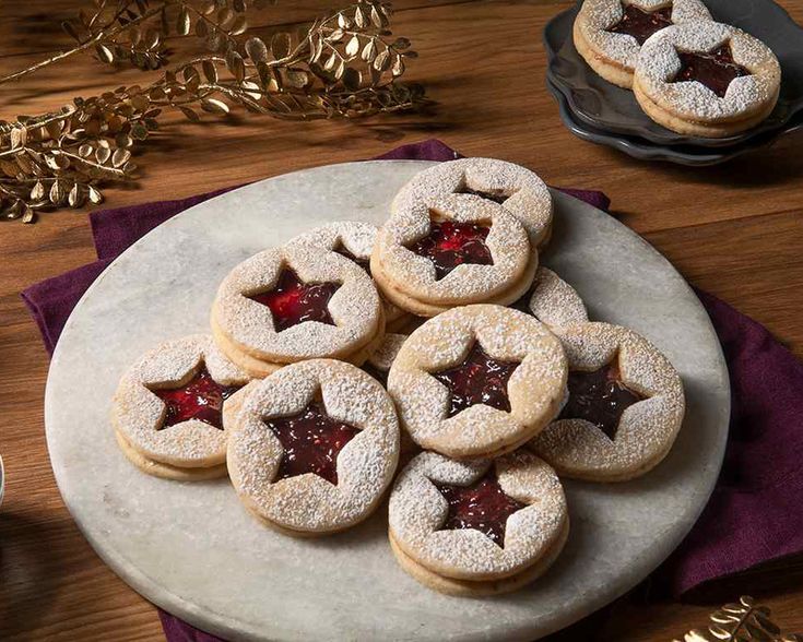 some cookies with red stars on them are sitting on a plate next to silverware