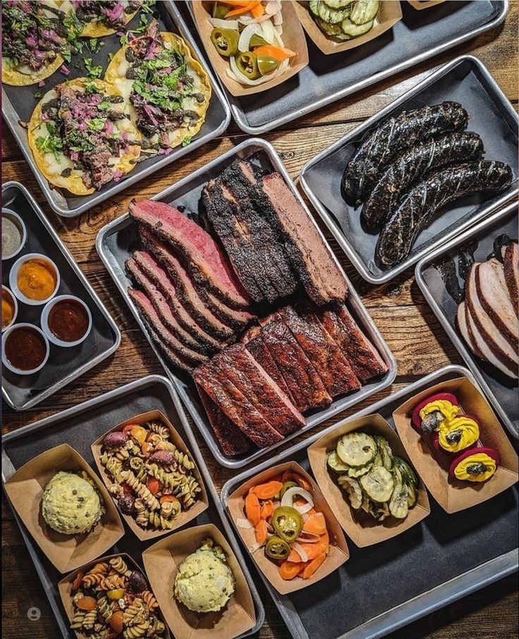 several trays filled with different types of food on top of a wooden table next to each other