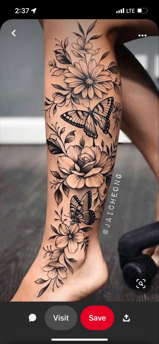 a woman's leg with flowers and butterflies on it