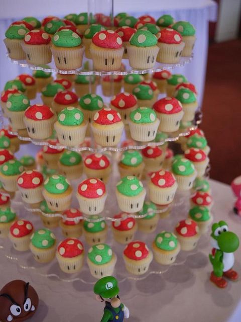 cupcakes are arranged in the shape of trees and toad's on display