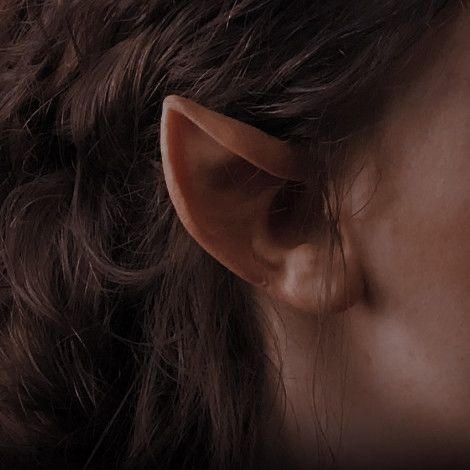 a close up of a person's ear with long hair