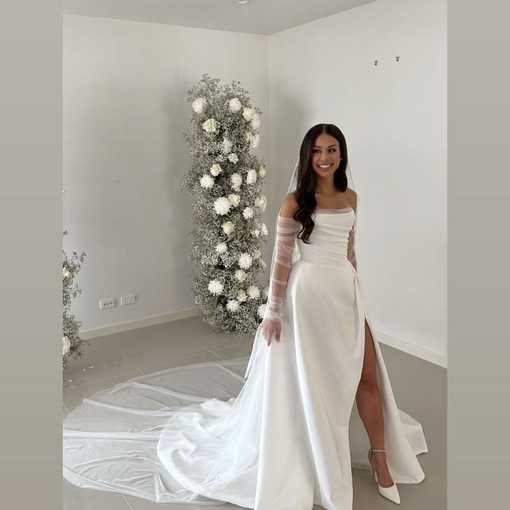 a woman in a white wedding dress posing for the camera