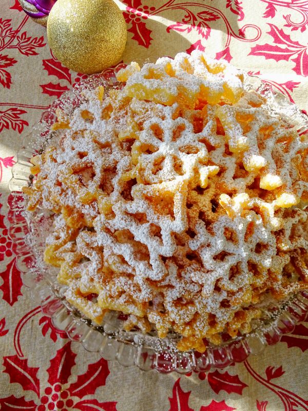 a bowl filled with powdered sugar next to an orange and christmas tree ornament