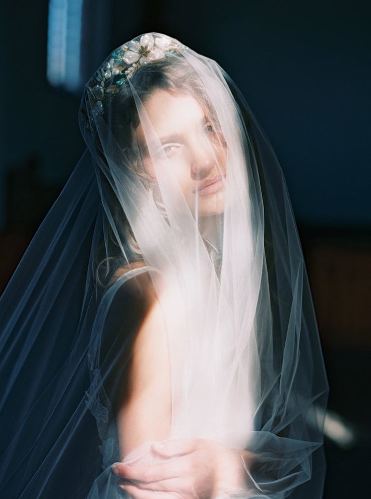 a woman in a wedding dress with a veil over her head