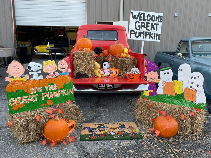 pumpkins and hay bales in front of a truck with peanuts on the bed