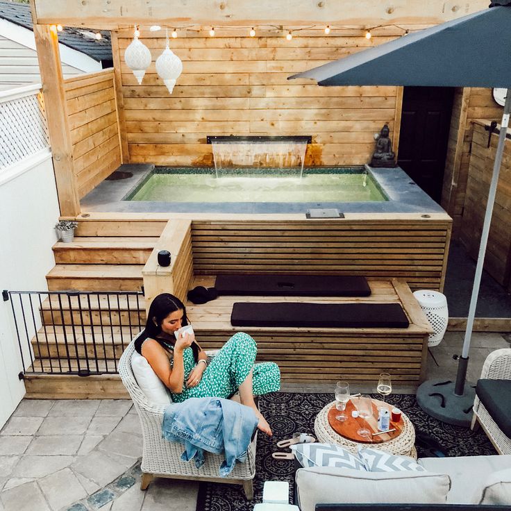 a woman sitting on a chair in front of a hot tub