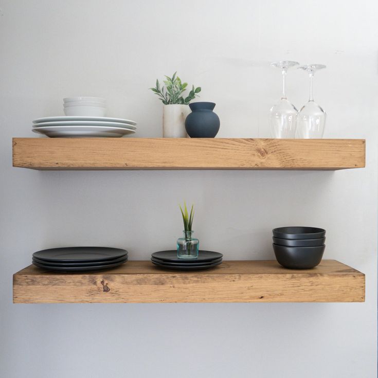 two wooden shelves with plates and bowls on them