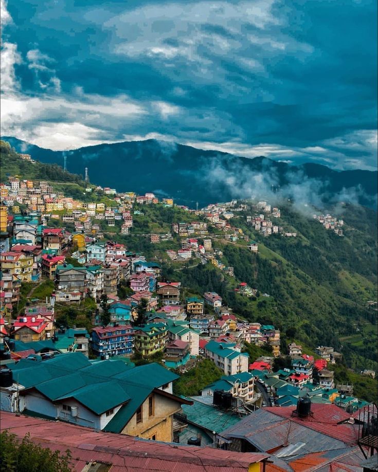 the city is surrounded by mountains and clouds