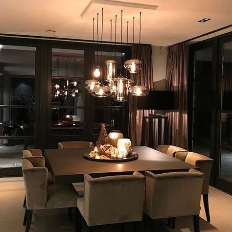 a dining room table and chairs with candles on it in front of a large window