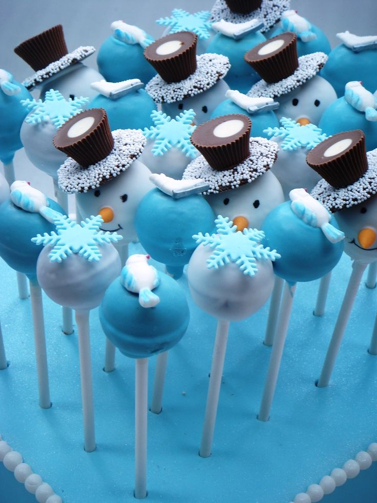 there are many cake pops with frosting and decorations on them in the shape of snowmen