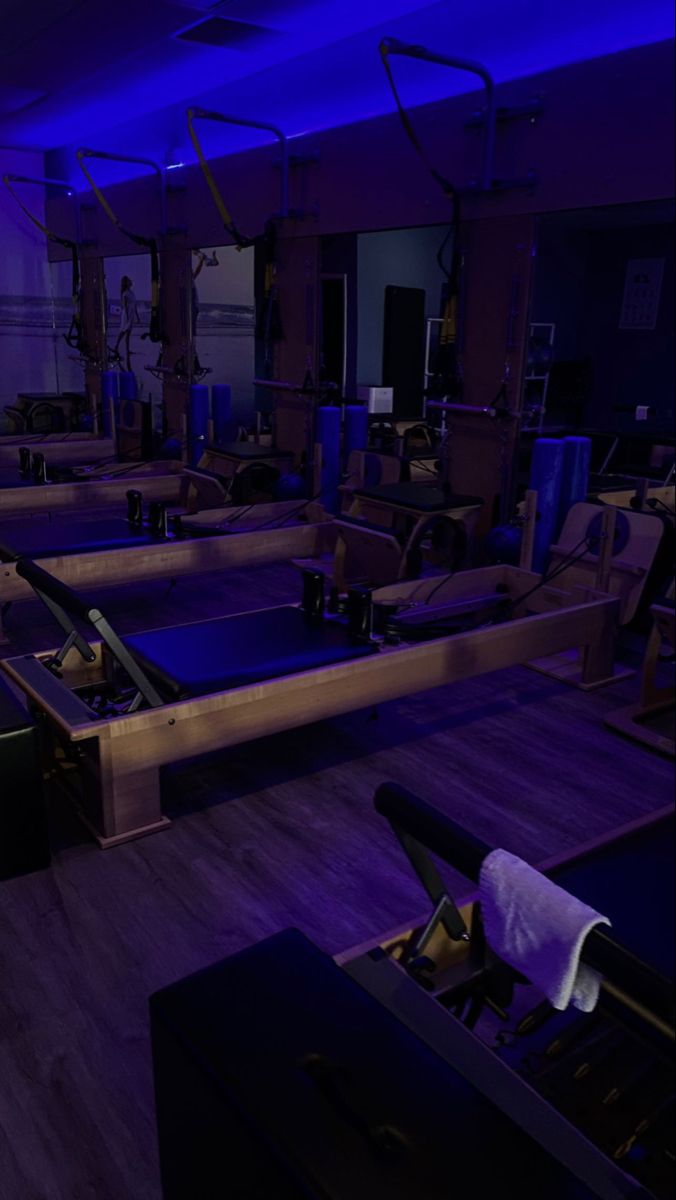 an empty gym with purple lighting and equipment