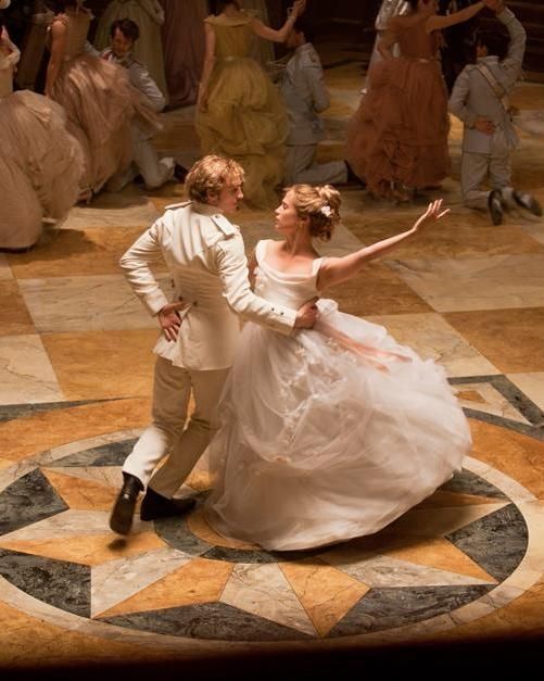 a man and woman dressed in white dancing