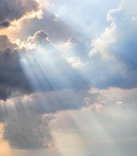 the sun rays shine through clouds over an open field