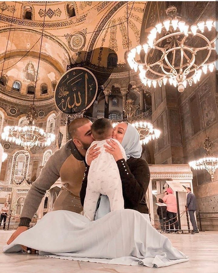 a man kneeling down next to a woman in front of a chandelier filled with lights