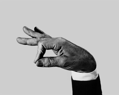 a black and white photo of a person's hand holding something in the air