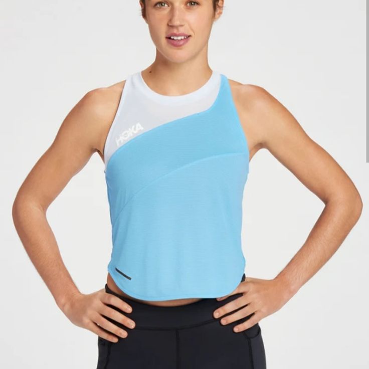 a woman is standing with her hands on her hips and wearing a blue tank top