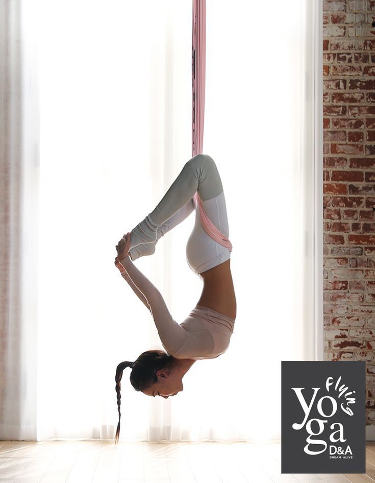 a woman doing a handstand in front of a window