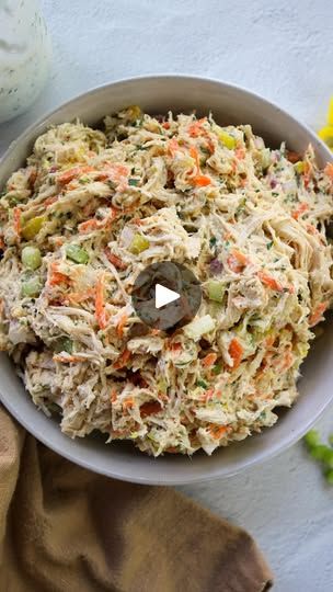 a white bowl filled with coleslaw and carrots next to a jar of mayonnaise