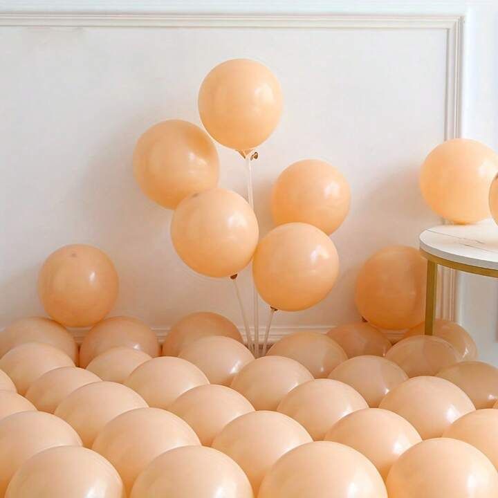 balloons are floating in the air near a small table and chair with a mirror on it