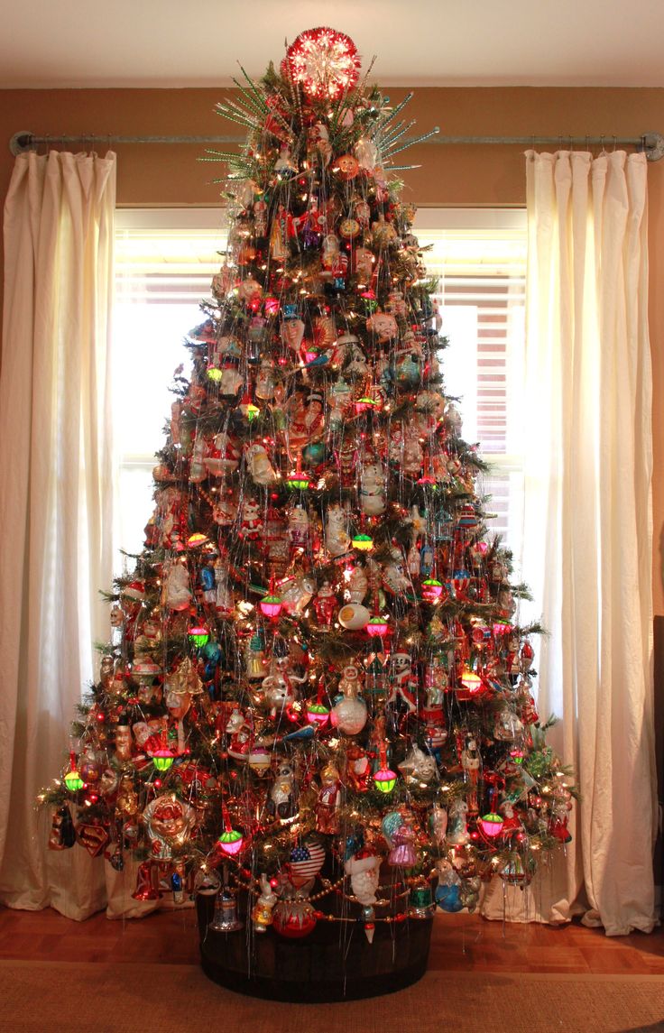 a decorated christmas tree in front of a window