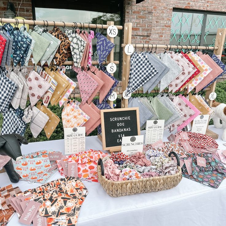 a table topped with lots of different types of cloths next to a sign that says summer sale