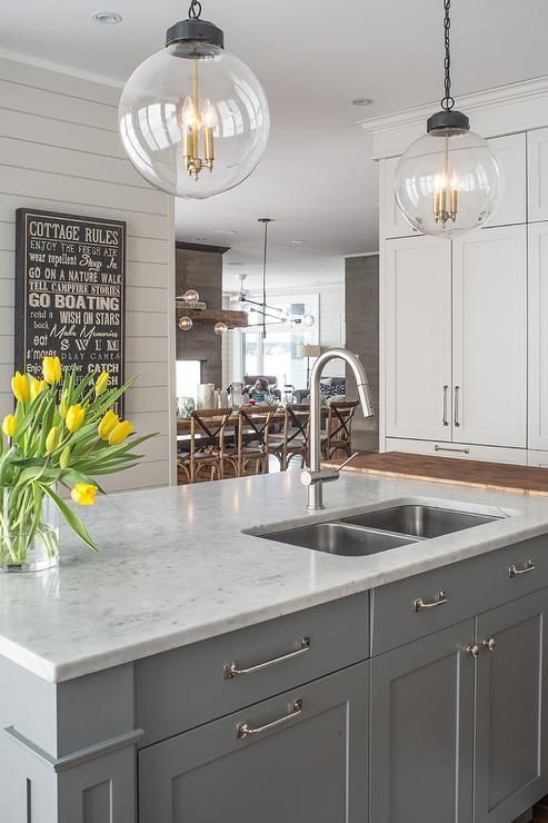 a large kitchen with white cabinets and yellow flowers in the center island countertop area