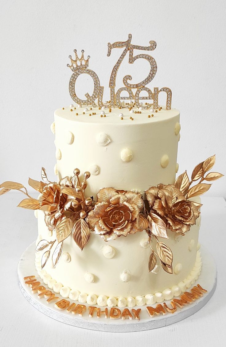 there is a white cake with gold flowers on it and the number twenty seven on top