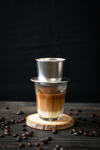 a cup of coffee sitting on top of a wooden coaster next to some coffee beans