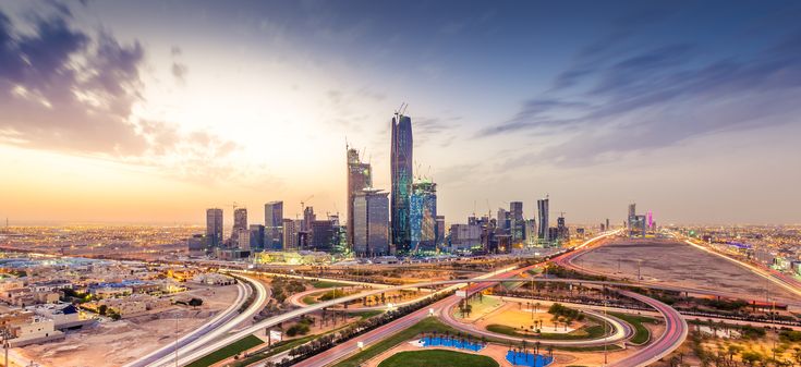 an aerial view of a city at sunset with traffic and skyscrapers in the background