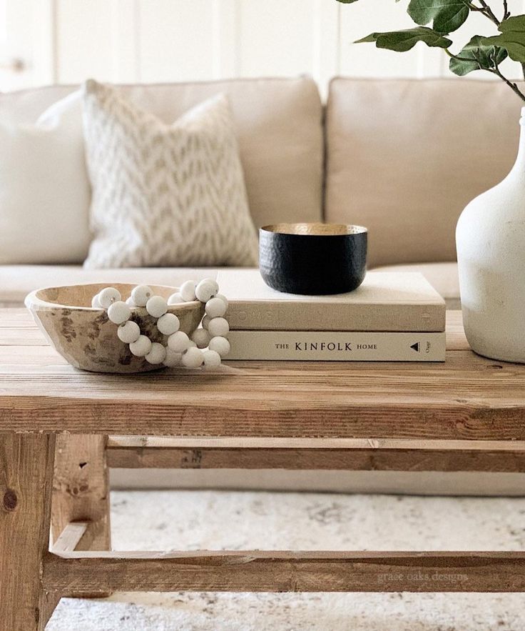 a coffee table with books and a vase on it