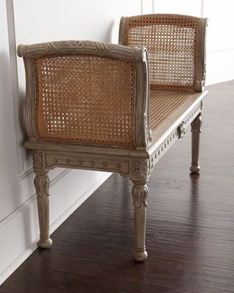 a wooden bench sitting on top of a hard wood floor next to a white wall