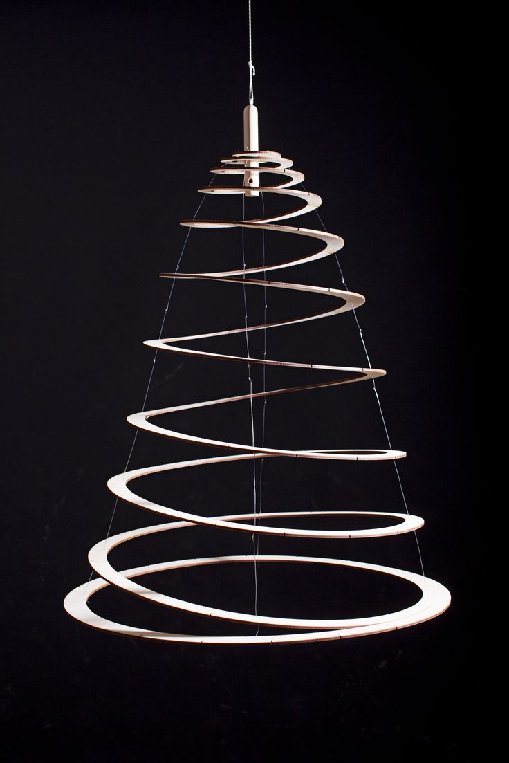 a christmas tree made out of white spirals on a black background with a light bulb hanging from the top