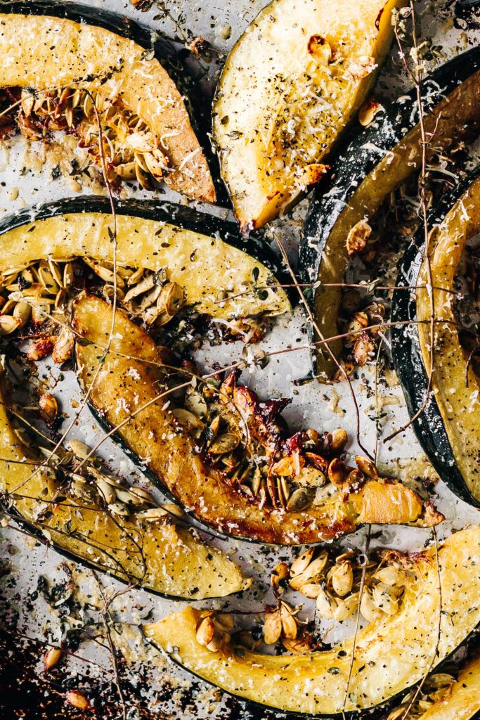 roasted pumpkins and pecans on a baking sheet covered in brown flecks