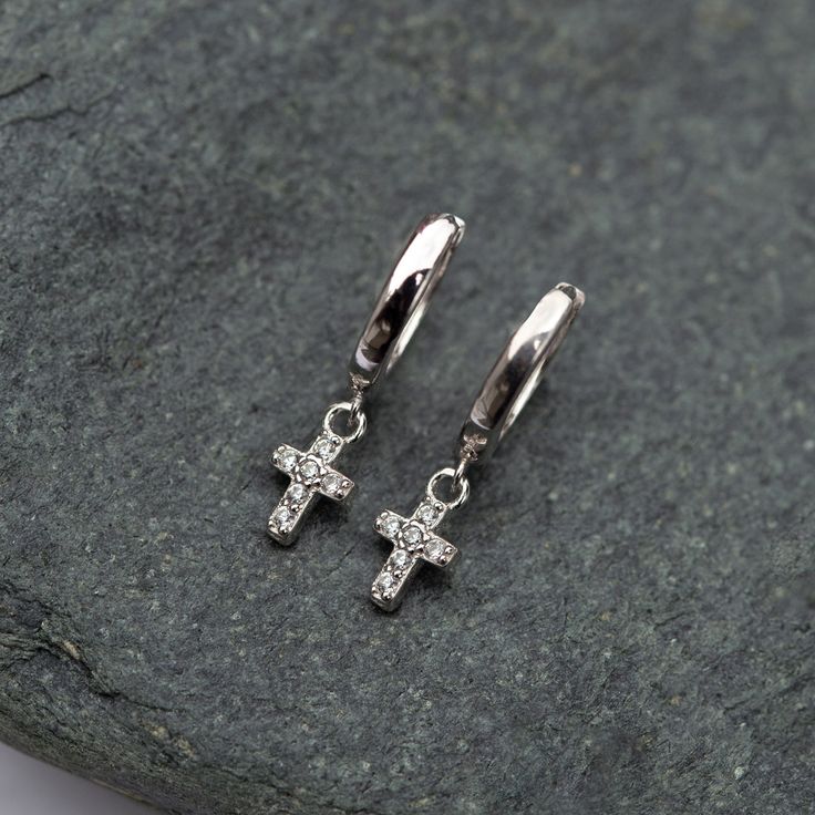 These Tiny Cross Silver Huggie earrings shimmer with every move. Minimal design made for those who are not too flashy. Great for those who have small earlobes. Perfect to wear on your secondary holes or cartilage for those with large earlobes. Sterling Silver Hypoallergenic, lead and nickel free Hoop Inside Diameter 7mm, Thickness 1.8mm Cross Height: 7mm Hinge Closure Handmade in NYC #E587-S Silver Huggie Earrings, Silver Cross Earrings, Huggie Earrings Silver, Tiny Cross, Ear Stack, Cross Earrings, Huggie Earrings, Sterling Silver Cross, Dainty Earrings