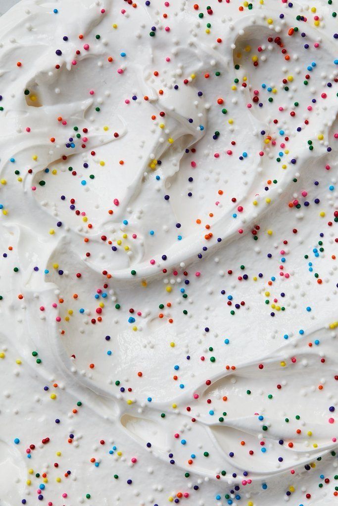 a cake with white frosting and colorful sprinkles