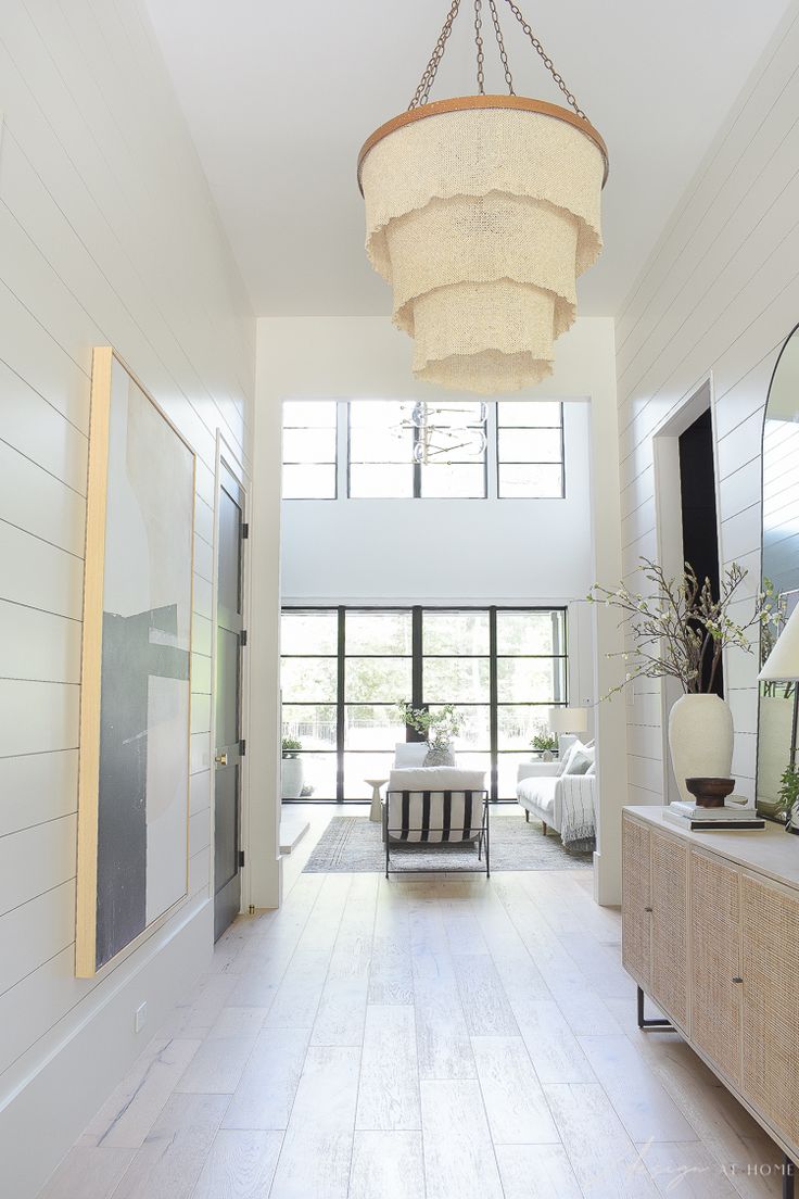 a living room with a large chandelier hanging over it's white walls