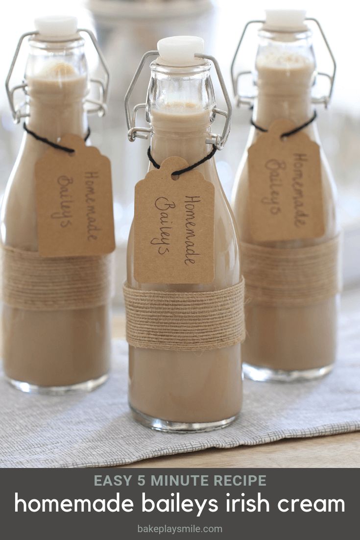 three empty bottles with labels on them sitting on a table next to a glass cup